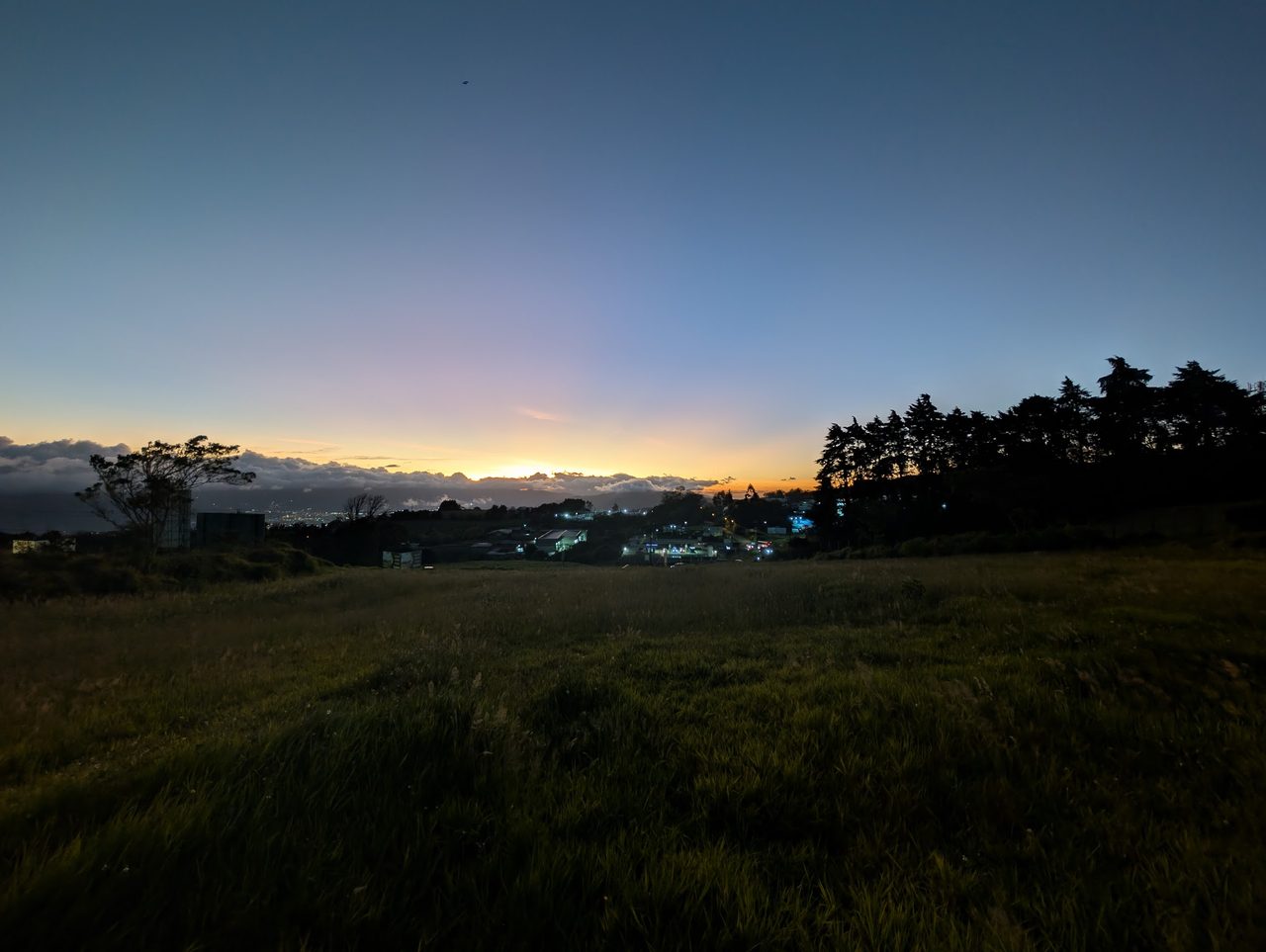 Atardecer azul y dorado sobre el campo verde